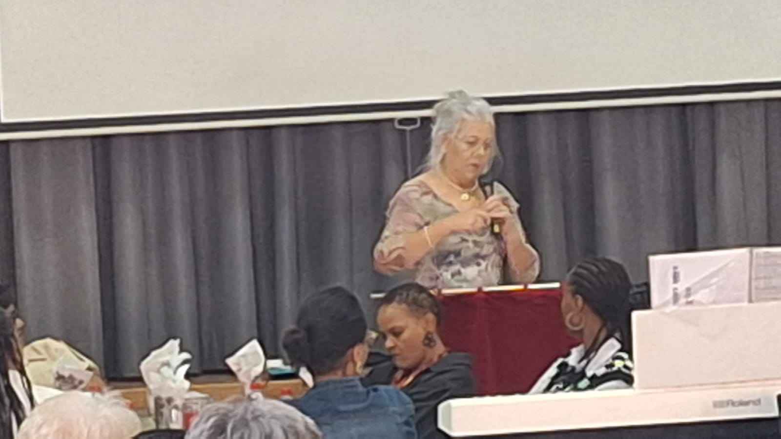 Karen speaking with a microphone at a community event