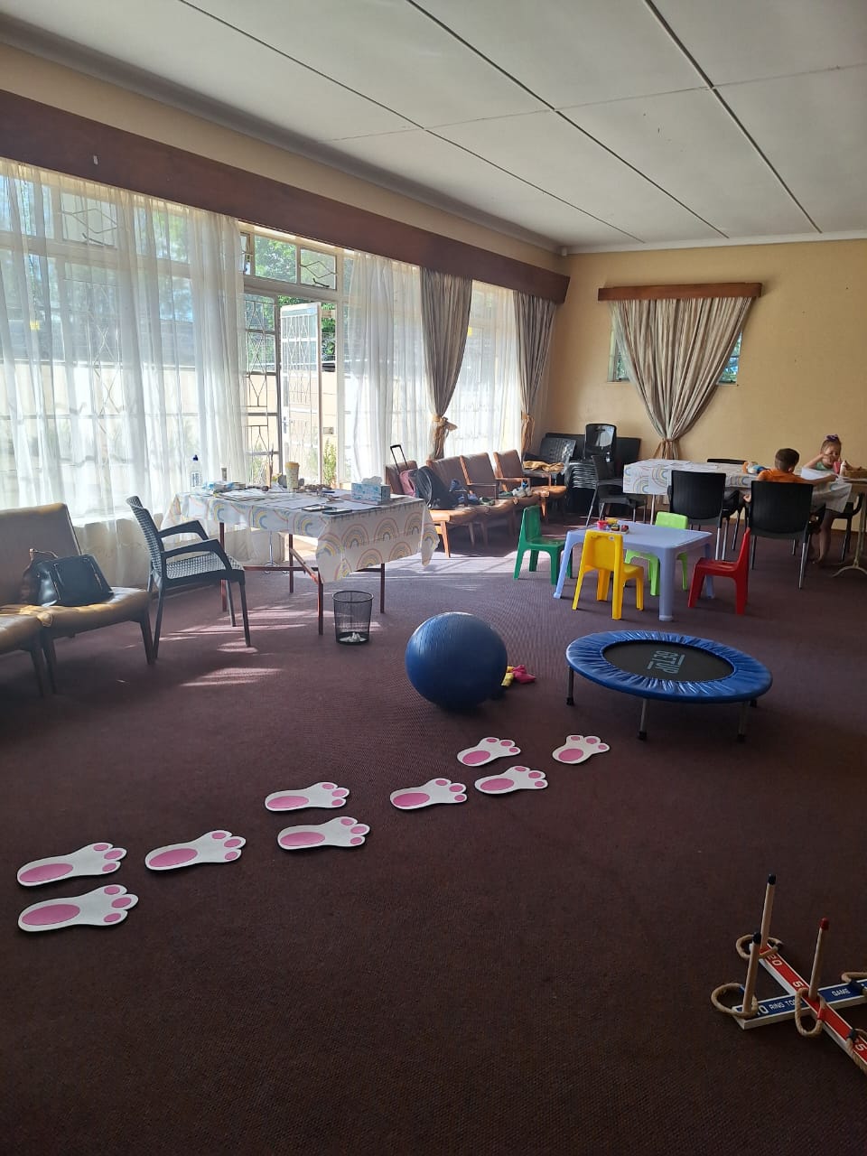 Bunny footprints leading across the carpet of the play room towards a gym ball and trampoline